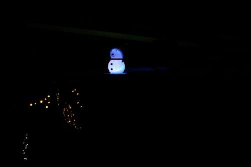 Schneemann und Lichterkette im Dunkeln